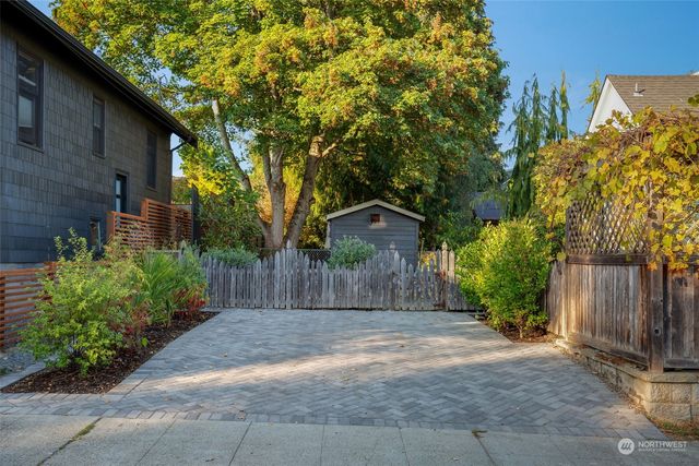 a front view of a house with a yard and tree