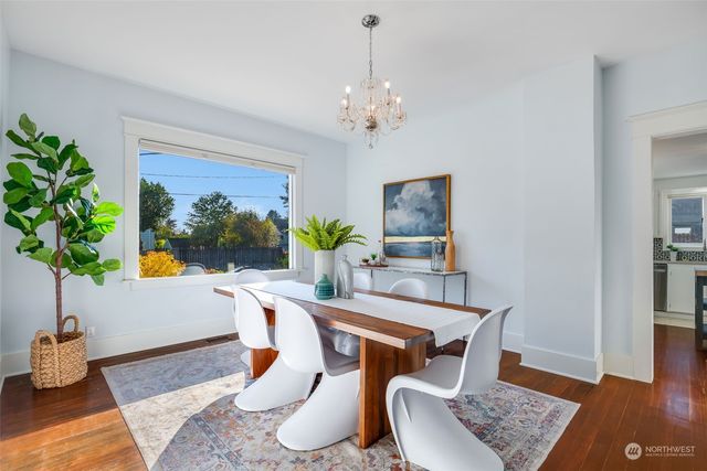 a dining room with wooden floor and a chandelier