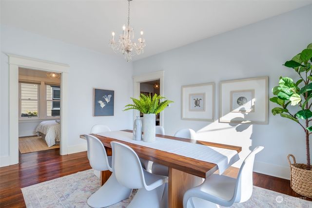 a dining room with furniture potted plants and wooden floor