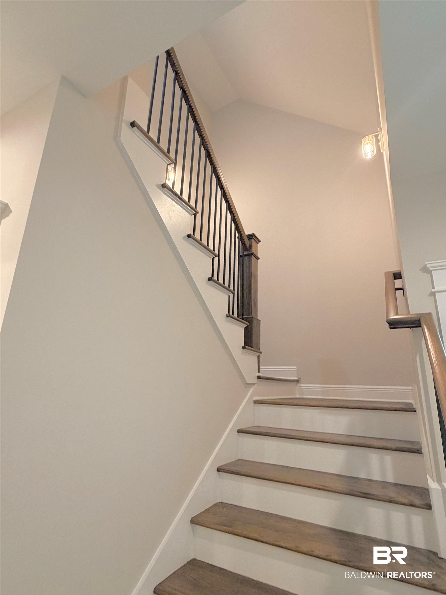 318 Morning Mist Way Fairhope, AL 36532 - Photo 11 of 20 Staircase featuring wood-finish treads, white risers, a dark wood newel post, and black metal balusters