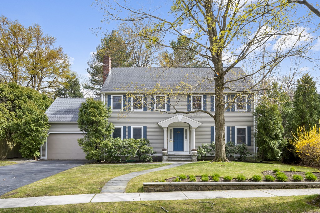 a view of a white house with a large yard and large tree