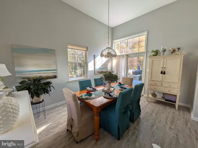 a dining room with furniture potted plants and wooden floor