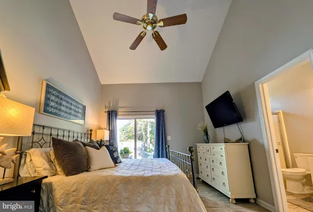 a bedroom with a bed a couch and a flat tv screen on the dresser