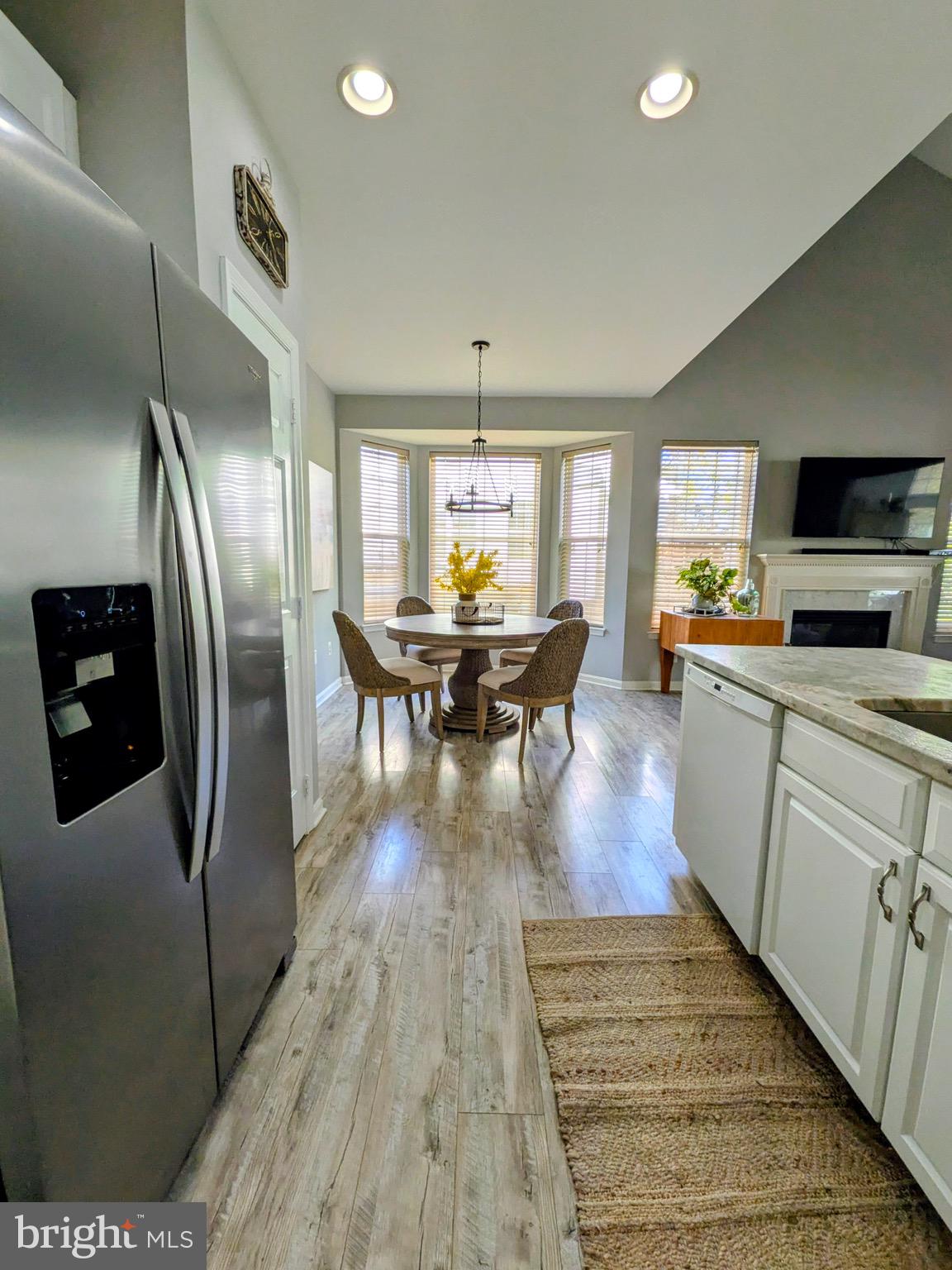 112 Chessie Court Chester, MD 21619 - Photo 4 of 37 a kitchen with stainless steel appliances granite countertop a refrigerator a stove top oven a sink dishwasher a dining table and chairs with wooden floor