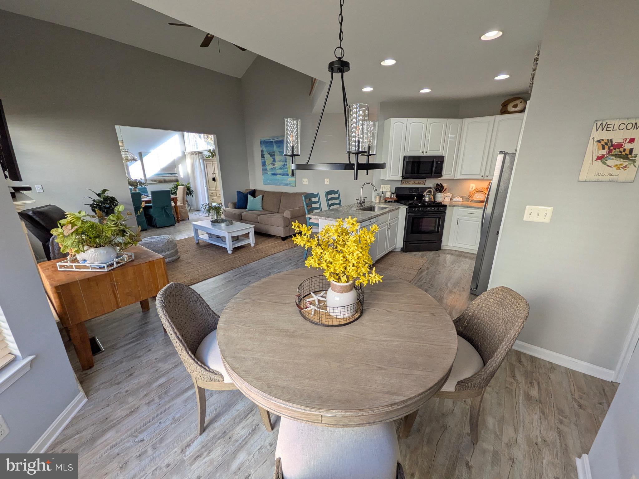112 Chessie Court Chester, MD 21619 - Photo 9 of 37 a kitchen with stainless steel appliances kitchen island granite countertop a dining table chairs stove refrigerator and cabinets