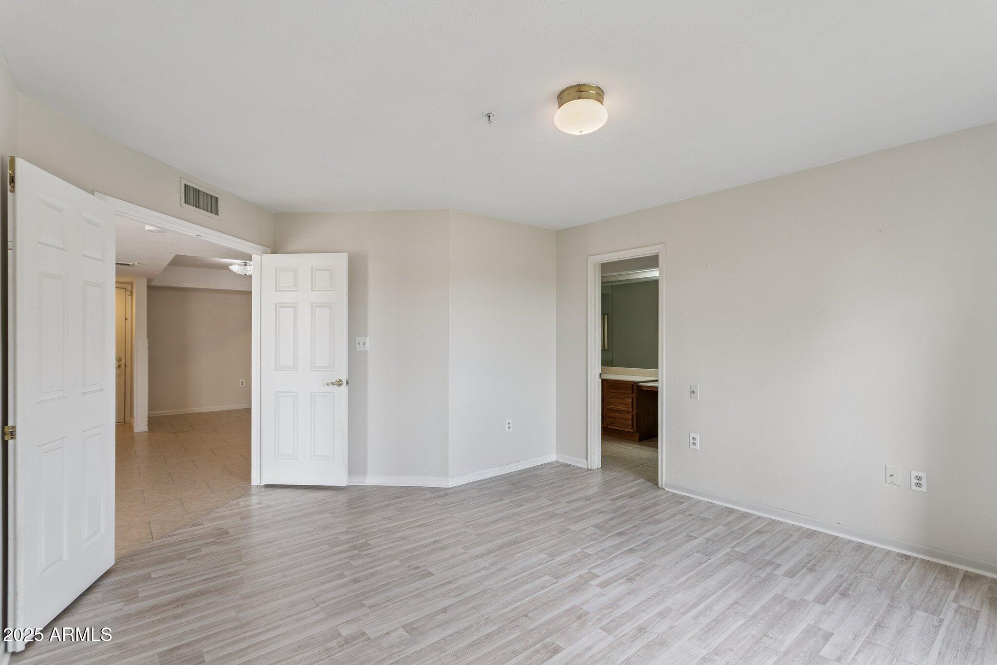 4200 North Miller Road, Unit 220 Scottsdale, AZ 85251 - Photo 13 of 27 a view of an empty room with wooden floor and closet