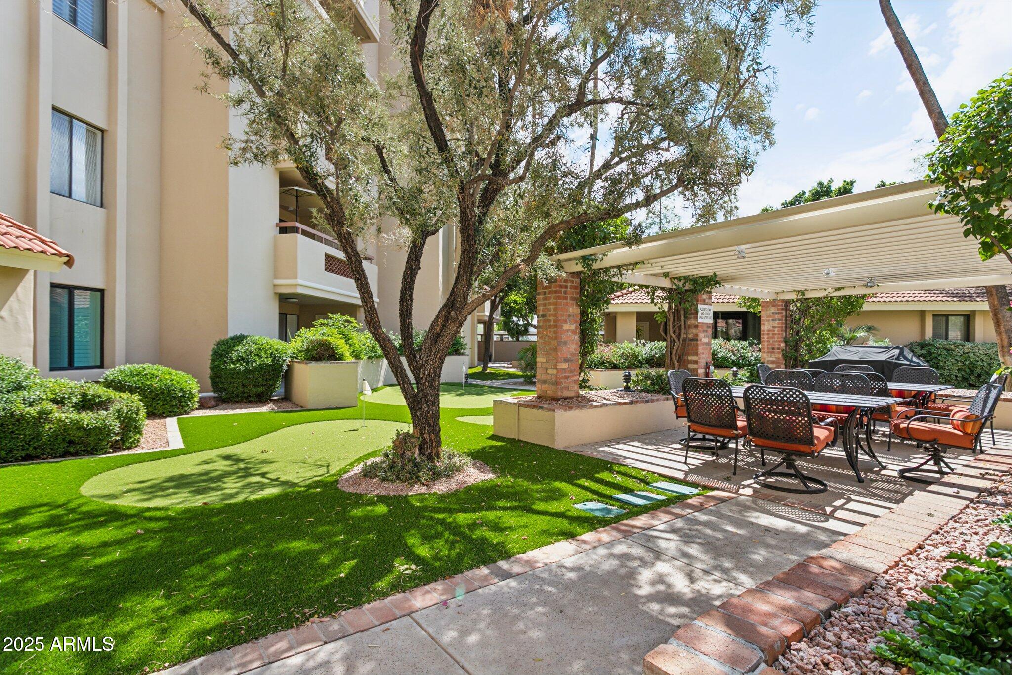 4200 North Miller Road, Unit 220 Scottsdale, AZ 85251 - Photo 21 of 27 a view of a patio with couches table and chairs next to a yard