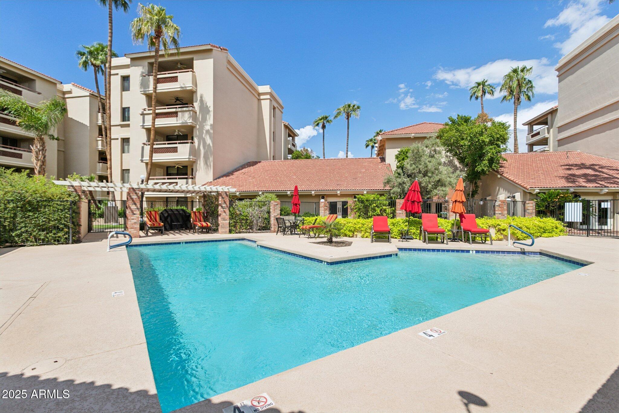 4200 North Miller Road, Unit 220 Scottsdale, AZ 85251 - Photo 25 of 27 a view of a swimming pool with a garden and plants