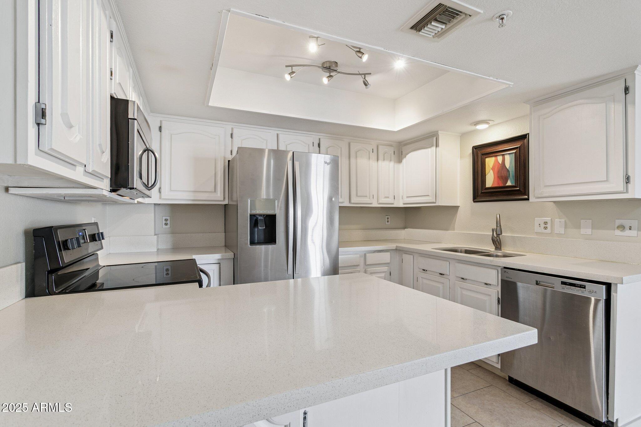 4200 North Miller Road, Unit 220 Scottsdale, AZ 85251 - Photo 5 of 27 a kitchen with stainless steel appliances granite countertop a sink stove and refrigerator