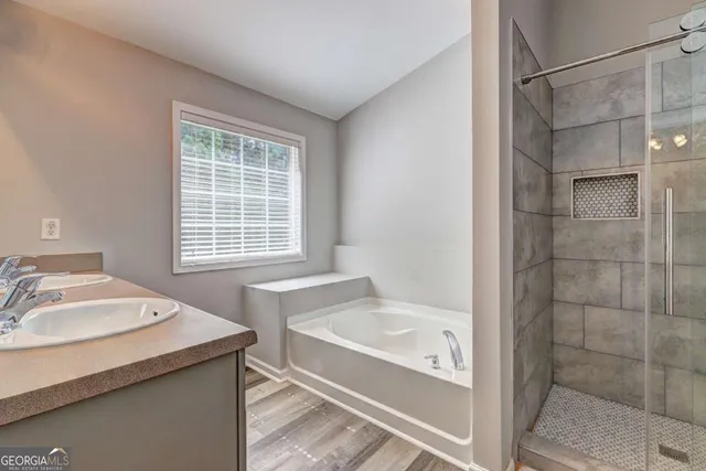 a bathroom with a granite countertop sink and a bathtub