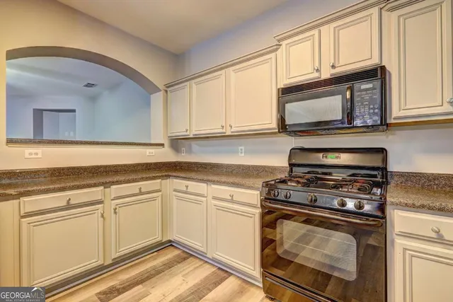 a kitchen with cabinets stainless steel appliances and a sink