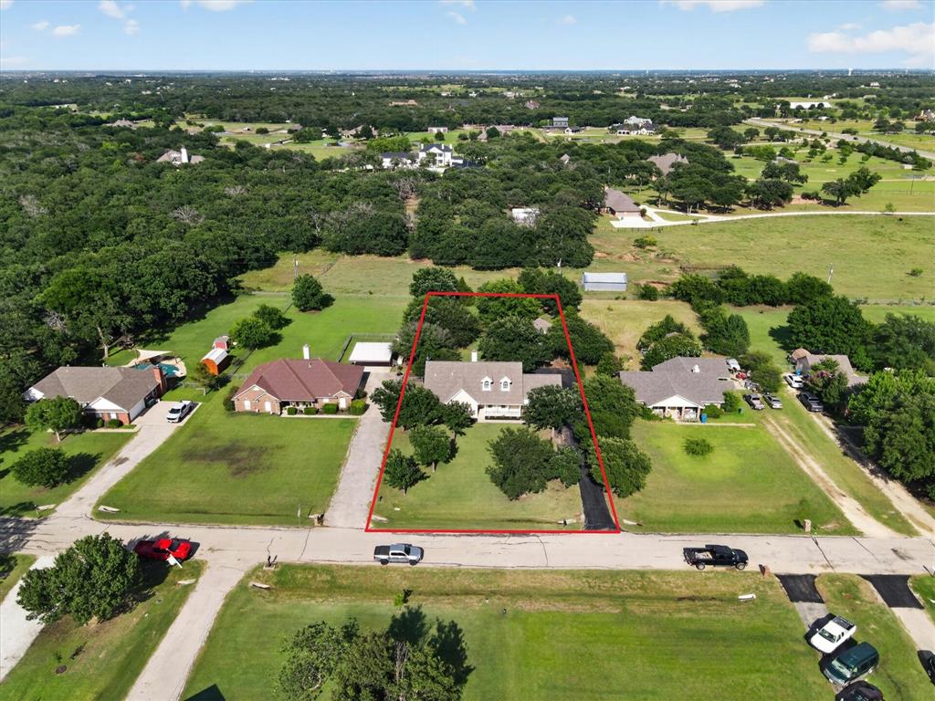 421 Ben Boyd Road Argyle, TX 76226 - Photo 23 of 25 White-sided residence with a dark roof and multiple dormer windows, situated on a verdant lot with mature trees