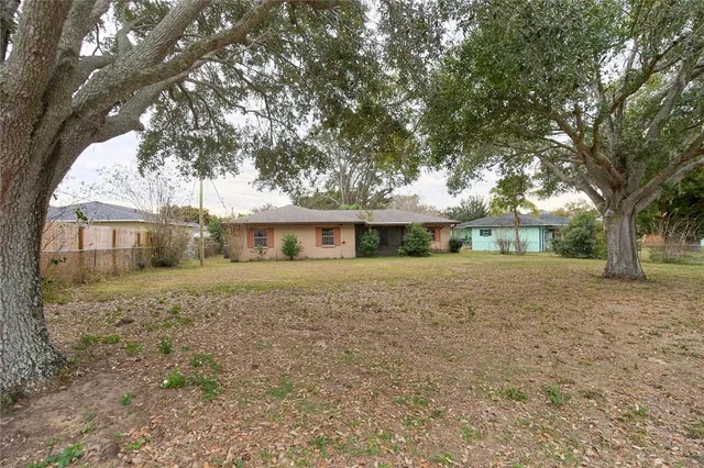 a front view of a house with a yard and trees