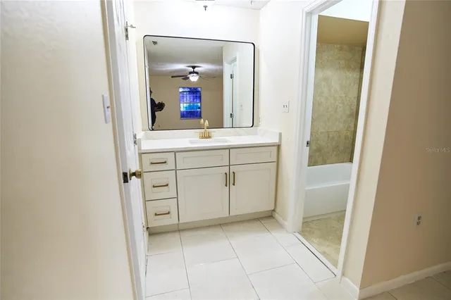 a spacious bathroom with a mirror and a sink