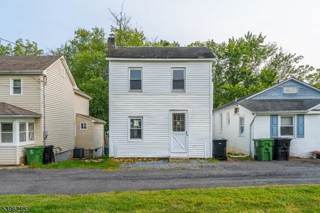 a view of a white house with a yard and plants