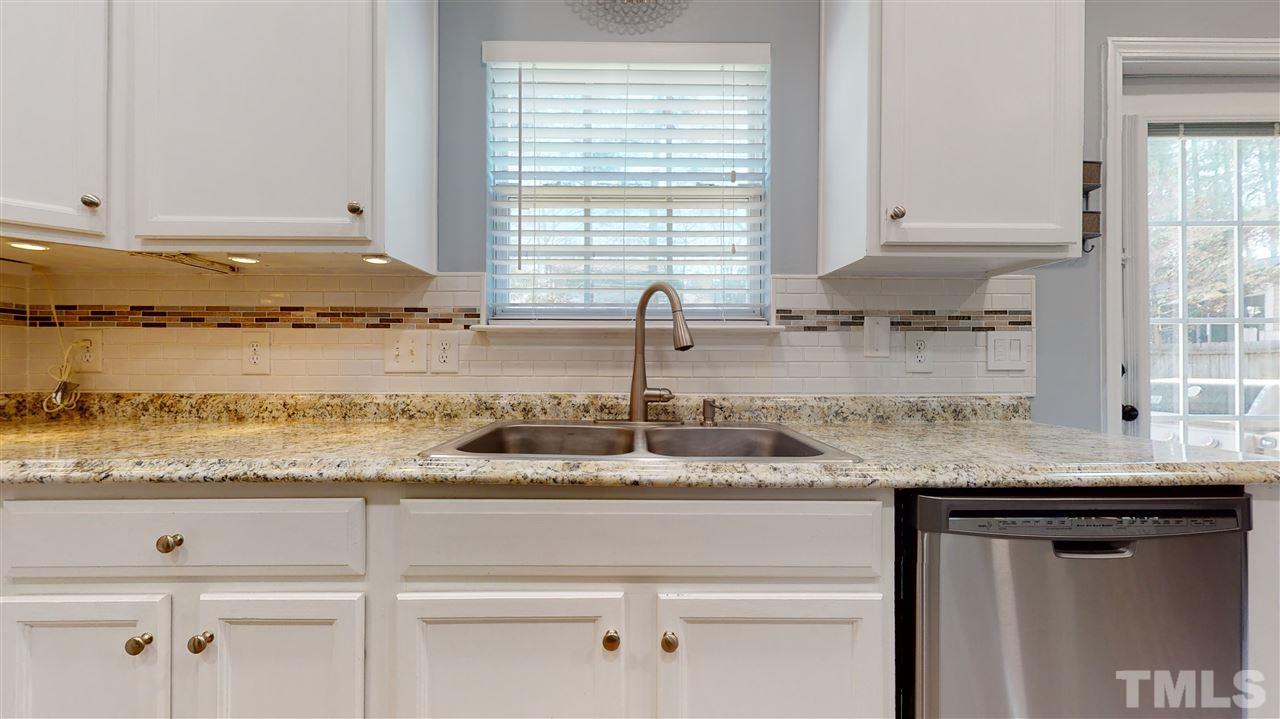 5404 Neuse Forest Road Raleigh, NC 27616 - Photo 15 of 29 a kitchen with granite countertop white cabinets and a window