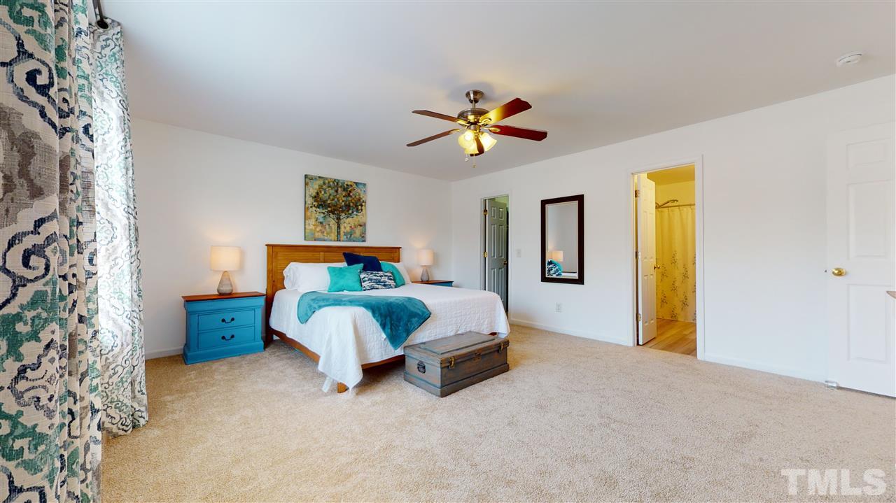 5404 Neuse Forest Road Raleigh, NC 27616 - Photo 18 of 29 a bedroom with a bed and a chandelier