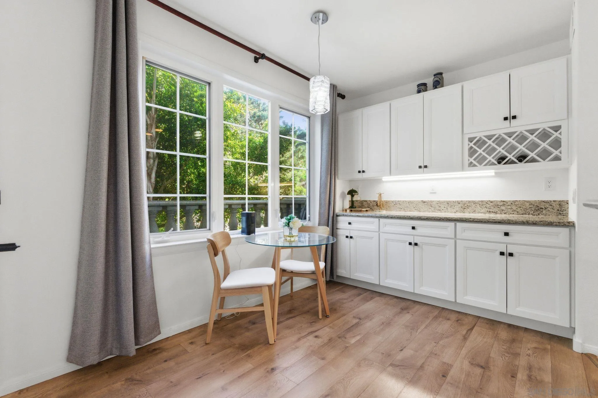 2842 Torrey Pines Road La Jolla, CA 92037 - Photo 13 of 45 a kitchen with a sink and white cabinets with wooden floor