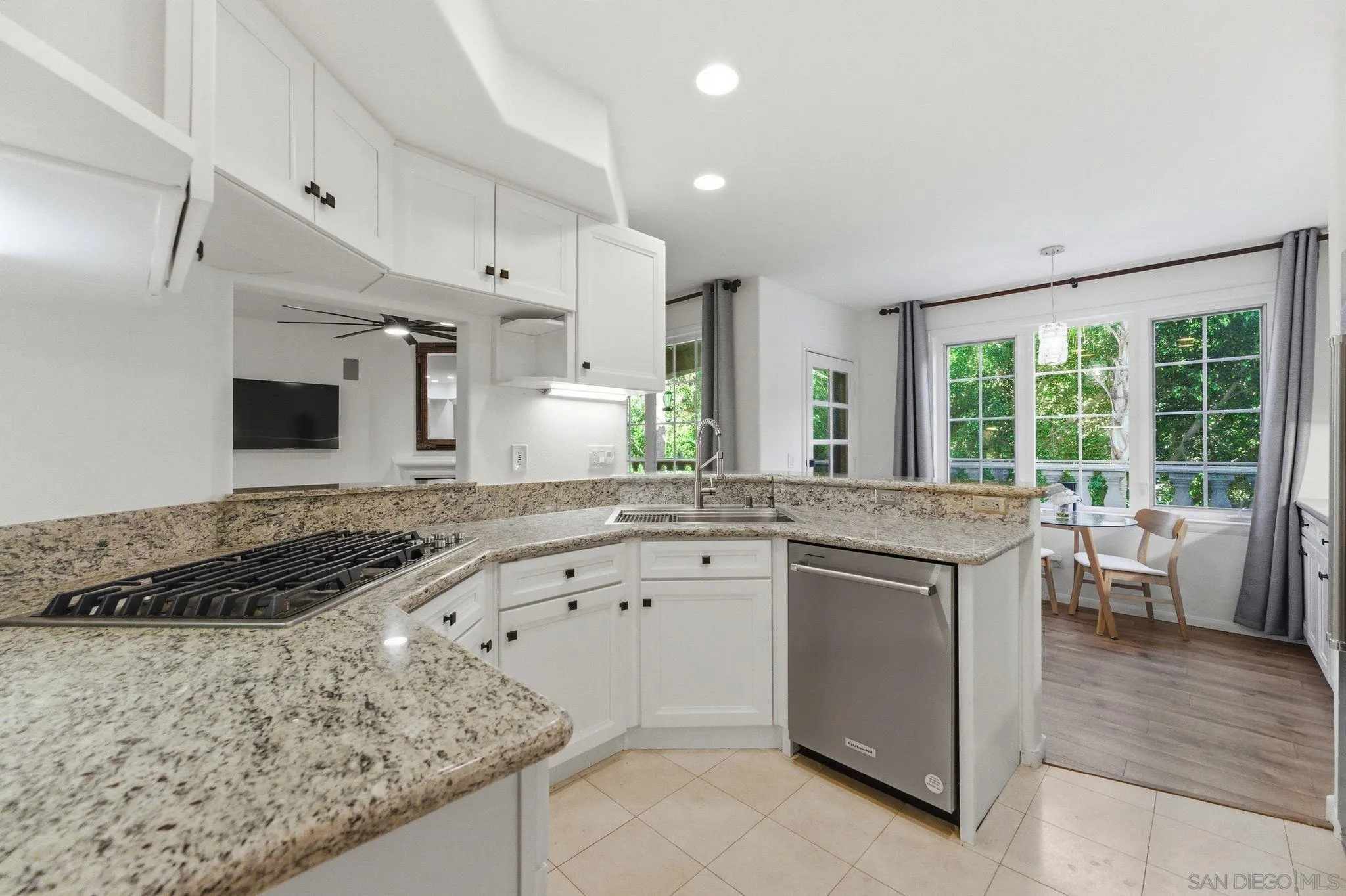 2842 Torrey Pines Road La Jolla, CA 92037 - Photo 9 of 45 a kitchen with a stove a sink a refrigerator and white cabinets with wooden floor