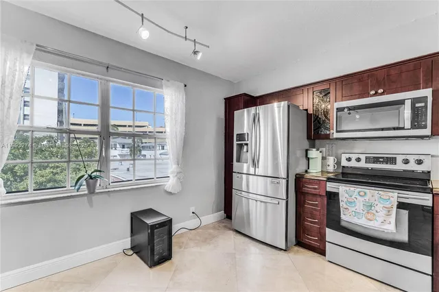 a kitchen with stainless steel appliances granite countertop a refrigerator sink and stove