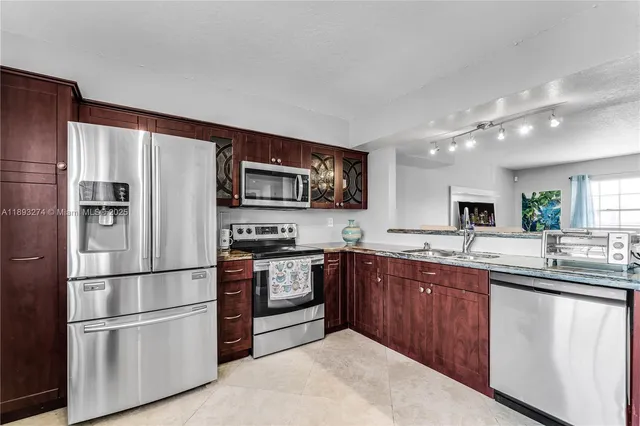 a kitchen with stainless steel appliances granite countertop a sink and cabinets