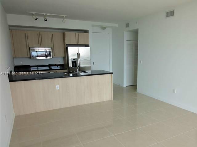 79 Southwest 12th Street, Unit 3502S Miami, FL 33130 - Photo 3 of 18 a kitchen with stainless steel appliances a sink and a microwave