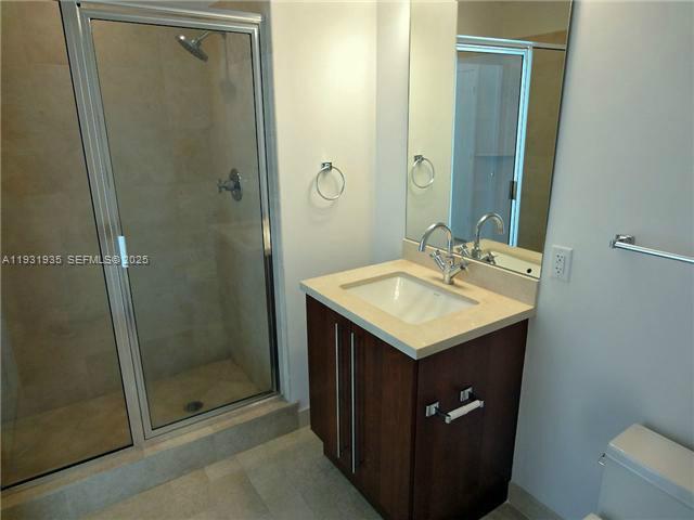 79 Southwest 12th Street, Unit 3502S Miami, FL 33130 - Photo 5 of 18 a bathroom with a shower sink and mirror