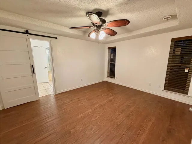 a view of an empty room with wooden floor