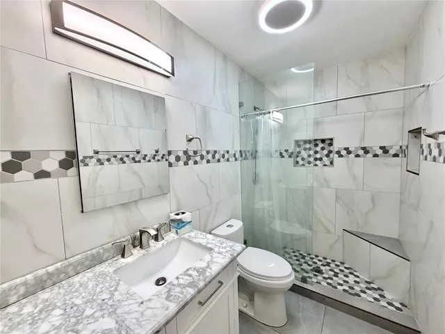 a bathroom with a sink toilet and shower