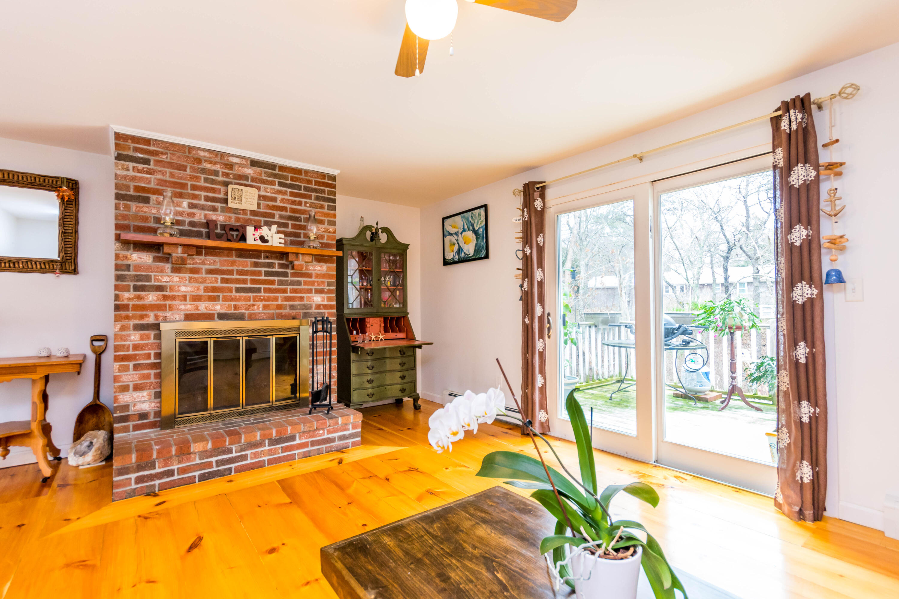 59 North Precinct Road Centerville, MA 02632 - Photo 4 of 30 a living room with a fireplace furniture and a large window