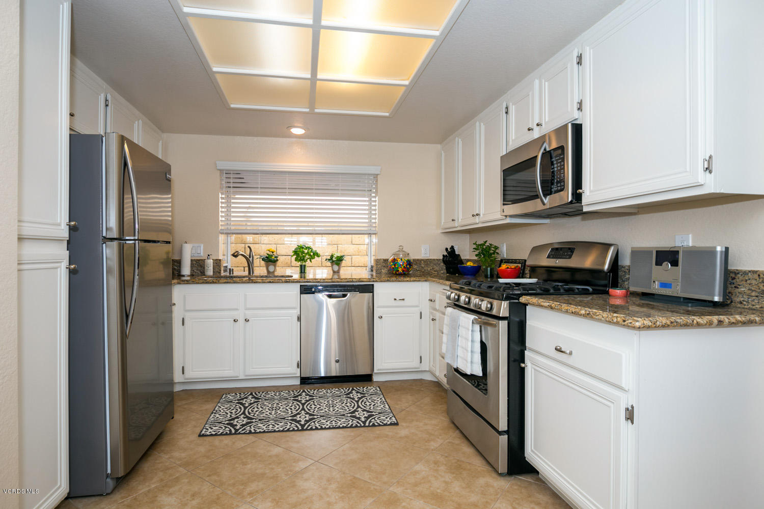 539 Galloping Hill Road Simi Valley, CA 93065 - Photo 12 of 30 a kitchen with stainless steel appliances granite countertop a refrigerator sink and white cabinets