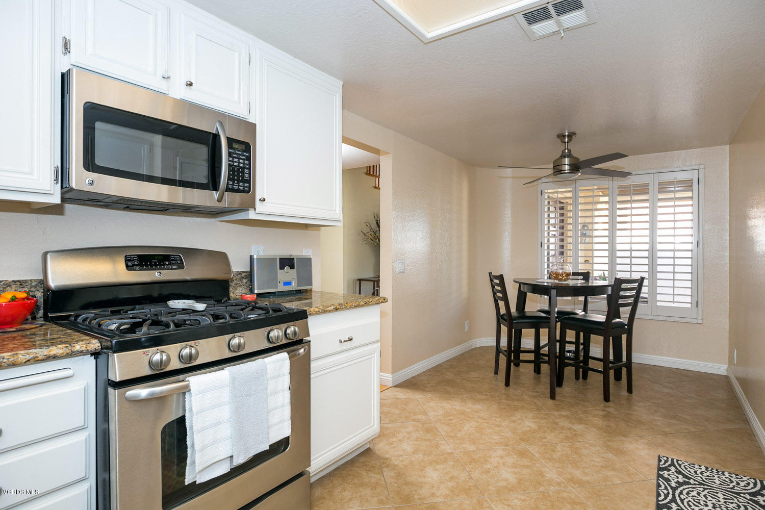 539 Galloping Hill Road Simi Valley, CA 93065 - Photo 13 of 30 a kitchen with stainless steel appliances granite countertop a stove a microwave a dining table and chairs