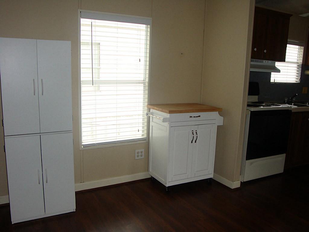2445 Precinct Line Road Richmond, TX 77406 - Photo 5 of 9 an empty room with wooden floor cabinet and windows