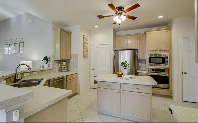 a kitchen with stainless steel appliances granite countertop a sink a stove and refrigerator