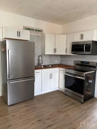 a white refrigerator freezer and a stove sitting inside of a kitchen with granite countertop a stove top oven