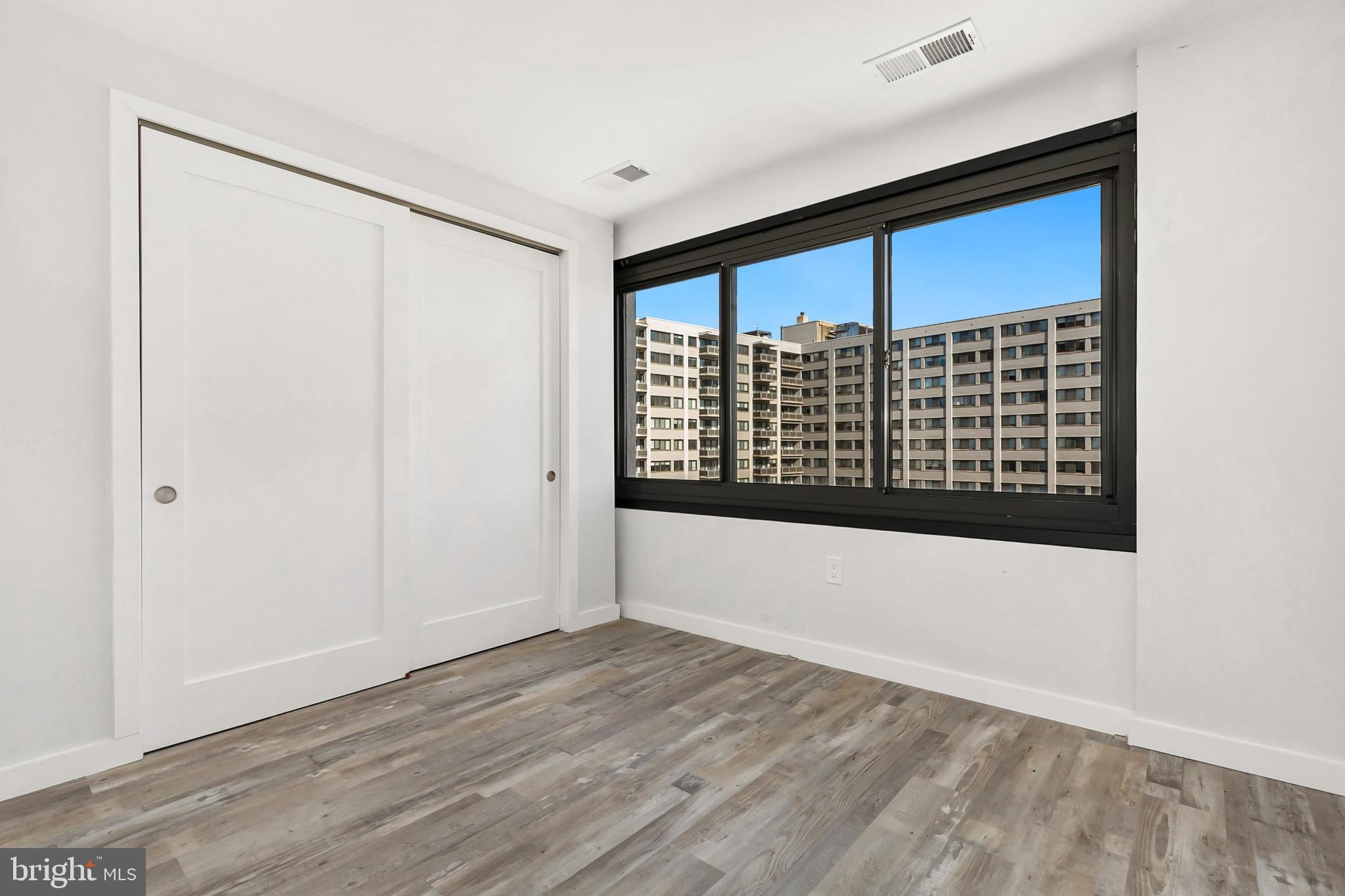 700 Roeder Road, Unit 603 Silver Spring, MD 20910 - Photo 8 of 21 a view of an empty room with wooden floor and a window
