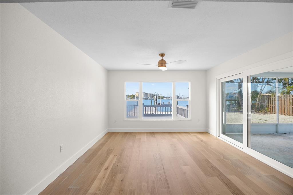 360 145th Avenue Madeira Beach, FL 33708 - Photo 15 of 64 a view of an empty room with wooden floor and a window