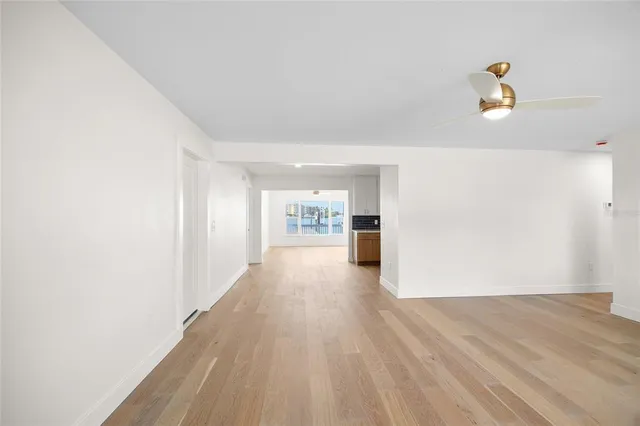 an empty room with wooden floor and window