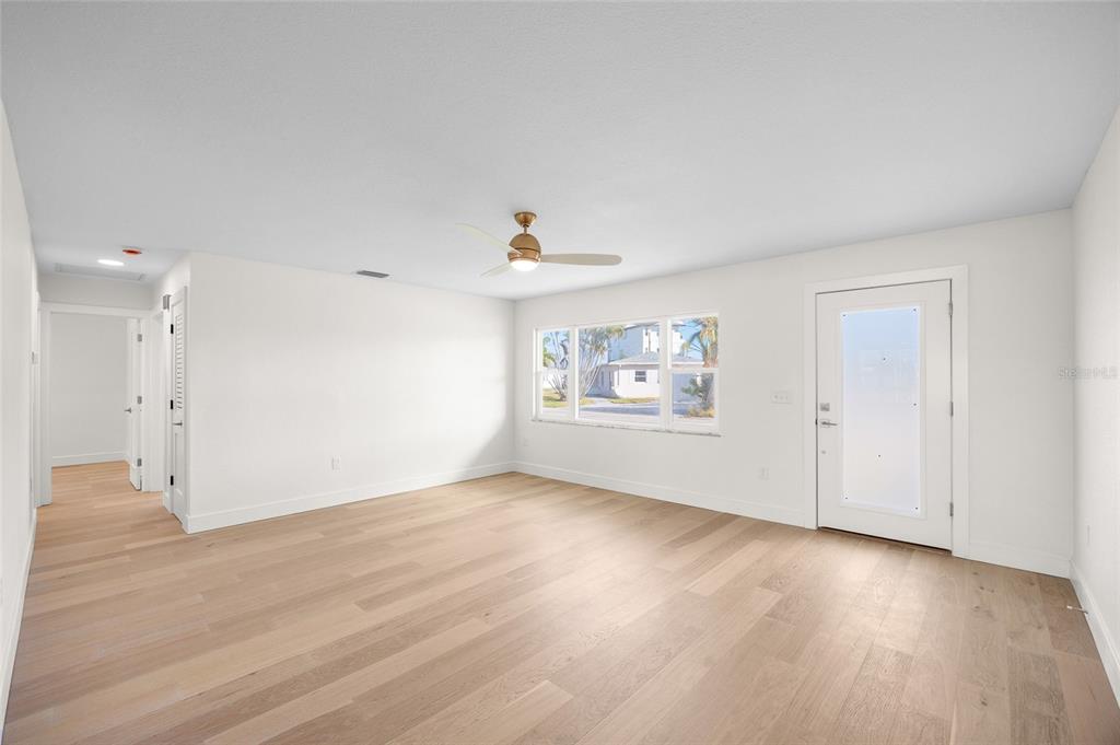 360 145th Avenue Madeira Beach, FL 33708 - Photo 19 of 64 an empty room with wooden floor and window