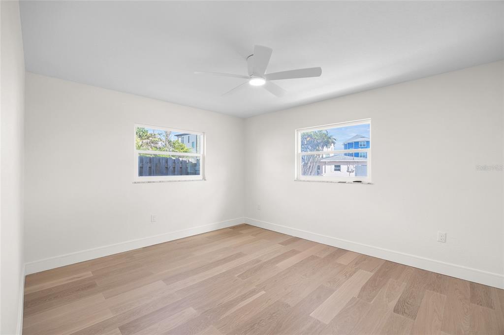 360 145th Avenue Madeira Beach, FL 33708 - Photo 26 of 64 an empty room with wooden floor and ceiling fan