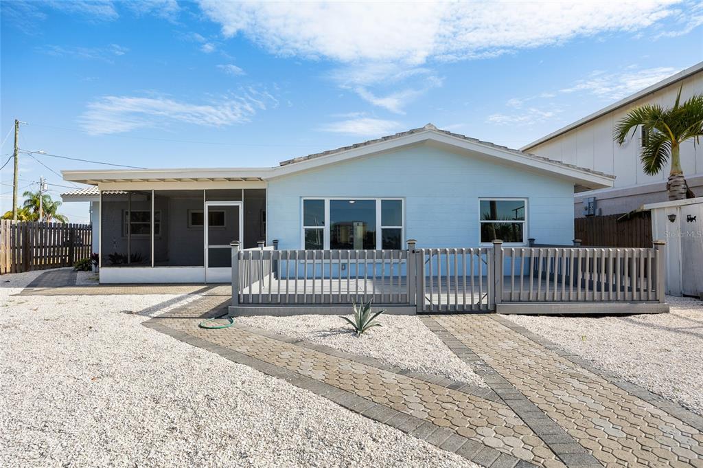 360 145th Avenue Madeira Beach, FL 33708 - Photo 35 of 64 a view of a house with a small yard and wooden fence