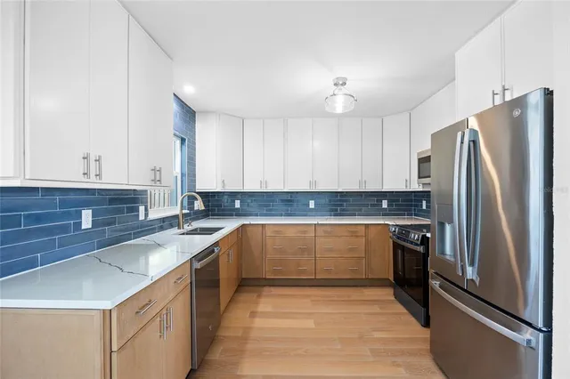 a kitchen with granite countertop a refrigerator and a sink