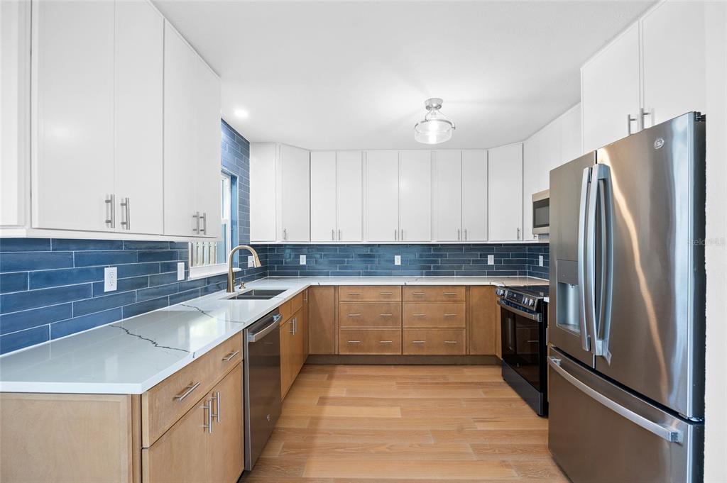 360 145th Avenue Madeira Beach, FL 33708 - Photo 4 of 64 a kitchen with granite countertop a refrigerator and a sink