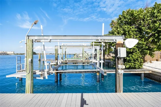 an aerial view of ocean and residential houses with outdoor space