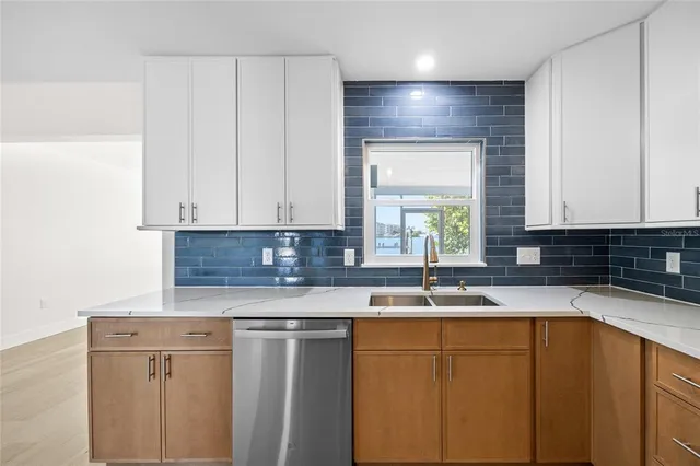 a kitchen with granite countertop white cabinets sink and window