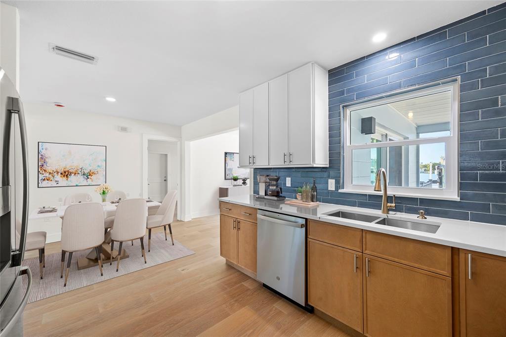 360 145th Avenue Madeira Beach, FL 33708 - Photo 7 of 64 a kitchen with white cabinets and sink
