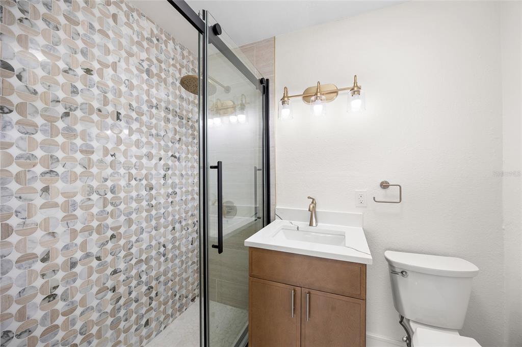 360 145th Avenue Madeira Beach, FL 33708 - Photo 10 of 64 a bathroom with a sink a toilet and shower