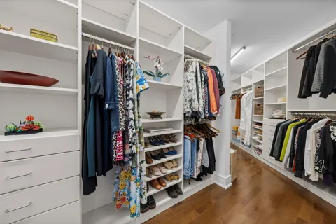 a view of walk in closet with clothes and shoes