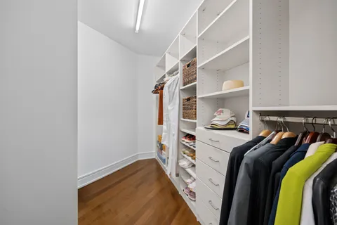 a view of walk in closet with clothes and shoes