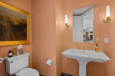 a bathroom with a sink mirror vanity and toilet